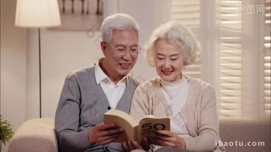 老年夫妇<strong>坐在沙发上</strong>看书